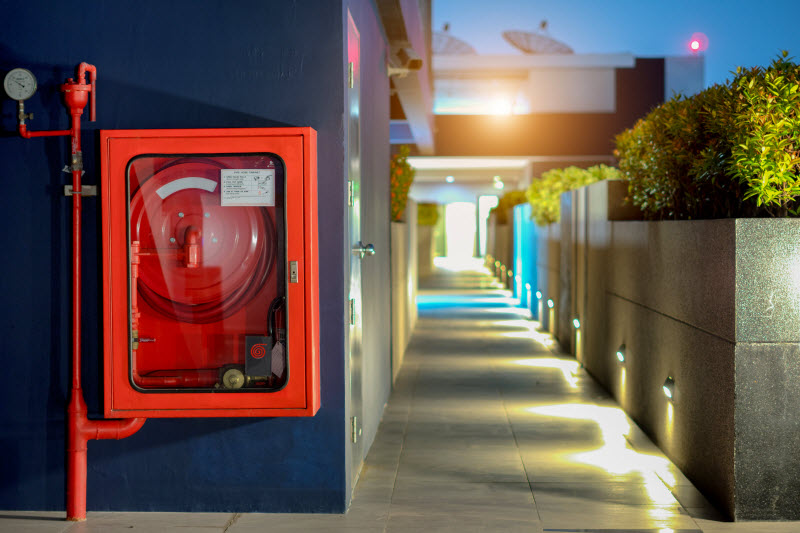 Fire extinguisher and fire hose reel in public building corridor